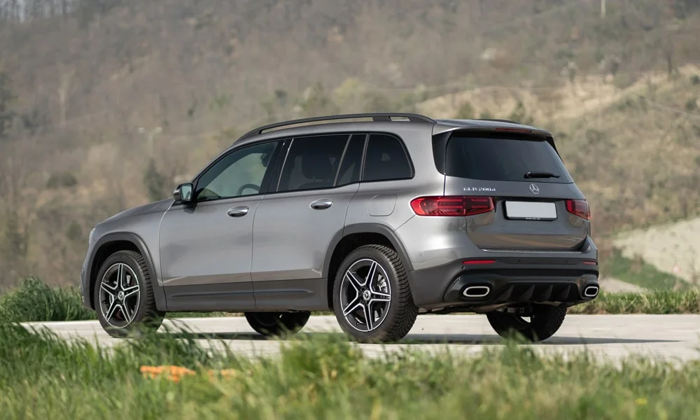 Фото Mercedes-Benz GLB (2024) — вид сзади. Серый кузов сзади — фонари и бампер определяют ночной образ модели. Насадки выхлопа или их имитация внизу бампера различают версии Mercedes-Benz GLB (2024) — вид сзади