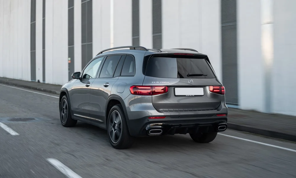 Фото Mercedes-Benz GLB (2024) — вид сзади, фото 6. Линия крыши, стойки и задняя дверь в сером исполнении. Светодиодная полоса или раздельные секции — задняя оптика стала главным украшением кормы Mercedes-Benz GLB (2024) — вид сзади, фото 6