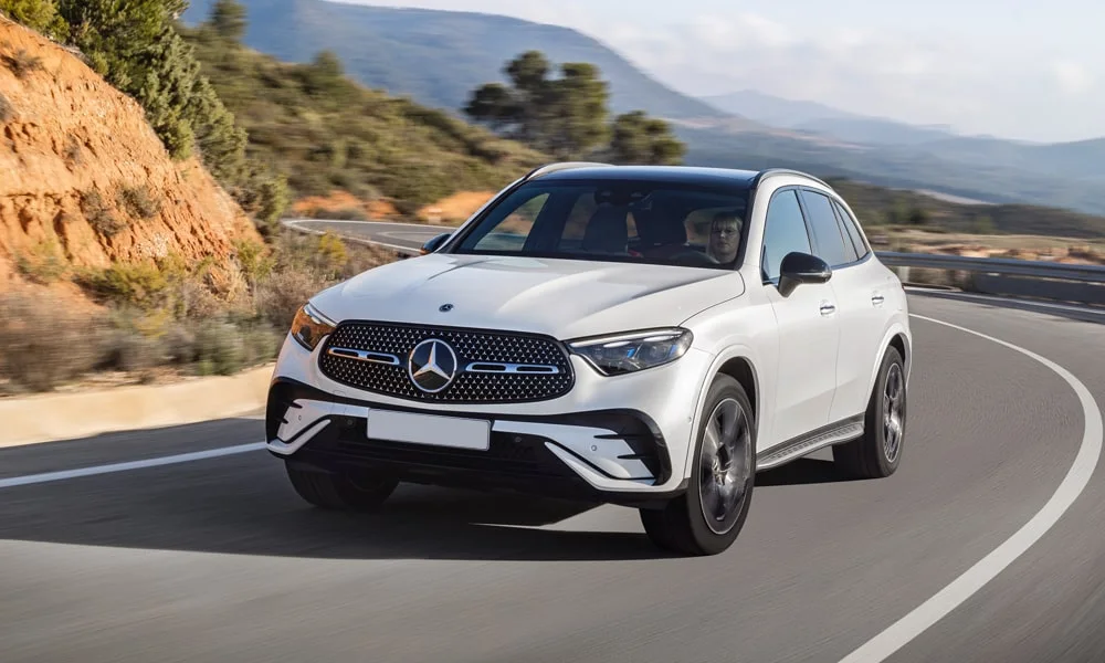Фото Mercedes-Benz GLC (2024) — вид спереди, фото 3. Кузов в белом цвете: рисунок оптики и решётки задаёт узнаваемое «лицо» модели Mercedes-Benz GLC (2024) — вид спереди, фото 3