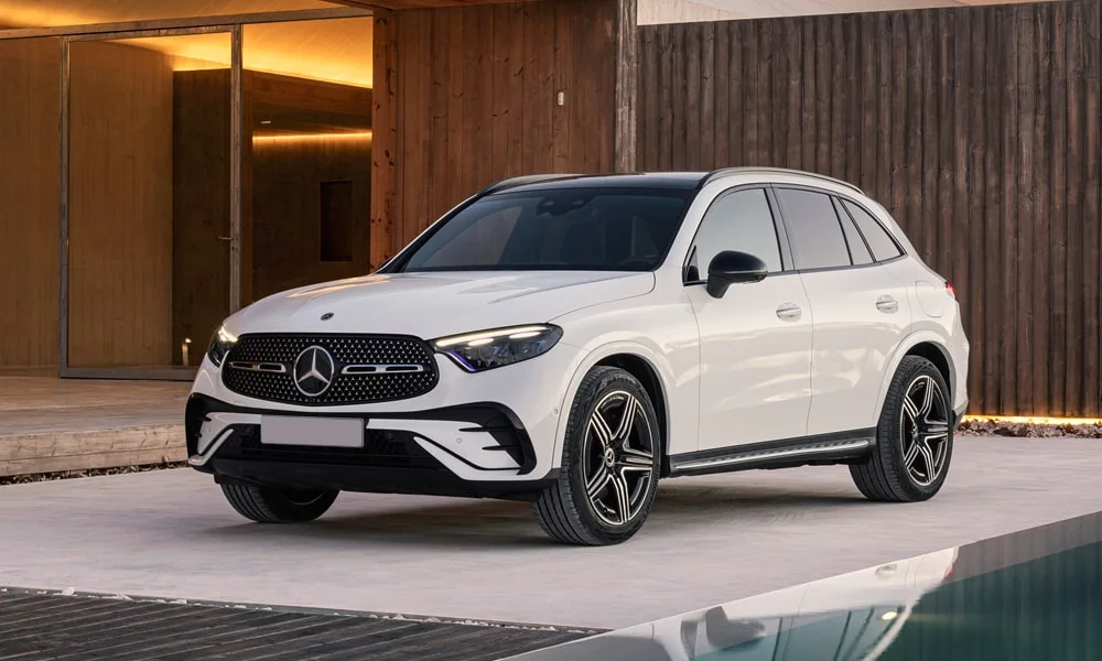 Фото Mercedes-Benz GLC (2024) — вид спереди, фото 7. Белый кузов, строгая симметрия оптики — базовый ракурс знакомства с дизайном. Рисунок ходовых огней — подпись модели, по нему её узнают в потоке Mercedes-Benz GLC (2024) — вид спереди, фото 7