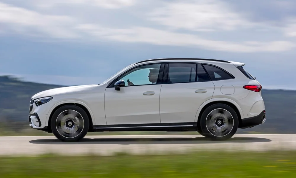 Фото Mercedes-Benz GLC (2024) — вид сбоку, фото 2. Профиль в белом цвете: соотношение колёсной базы и свесов. Хромированные или чёрные молдинги окон отличают комплектации Mercedes-Benz GLC (2024) — вид сбоку, фото 2