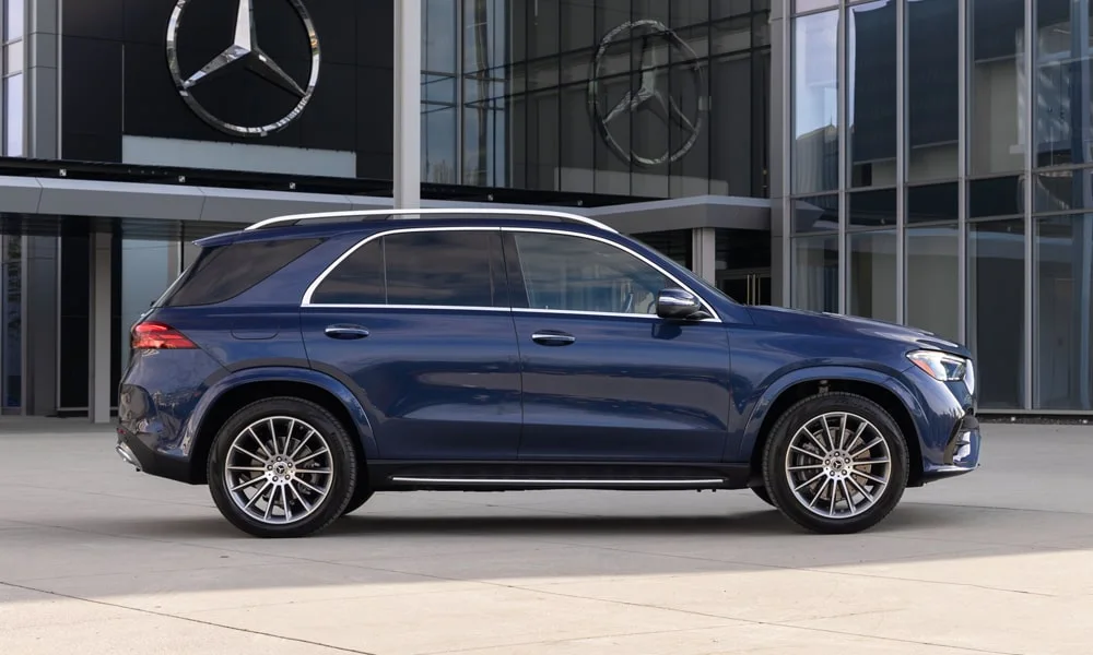 Фото Mercedes-Benz GLE (2024) — вид спереди, фото 13. Синий кузов, строгая симметрия оптики — базовый ракурс знакомства с дизайном. Дневные ходовые огни включаются автоматически с запуском Mercedes-Benz GLE (2024) — вид спереди, фото 13