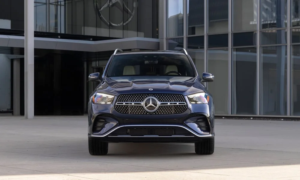 Фото Mercedes-Benz GLE (2024) — вид спереди, фото 14. Синий кузов, строгая симметрия оптики — базовый ракурс знакомства с дизайном Mercedes-Benz GLE (2024) — вид спереди, фото 14