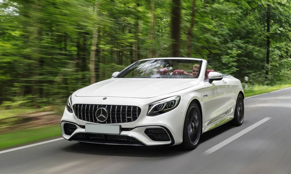 Фото Mercedes-Benz S-Class — вид спереди, фото 12. Белый кузов, строгая симметрия оптики — базовый ракурс знакомства с дизайном. Рисунок ходовых огней — подпись модели, по нему её узнают в потоке Mercedes-Benz S-Class — вид спереди, фото 12
