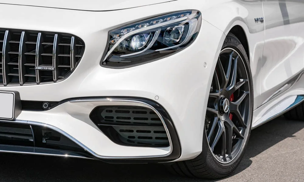 Фото Mercedes-Benz S-Class — вид спереди, фото 13. Кузов в белом цвете: рисунок оптики и решётки задаёт узнаваемое «лицо» модели. Рисунок ходовых огней — подпись модели, по нему её узнают в потоке Mercedes-Benz S-Class — вид спереди, фото 13