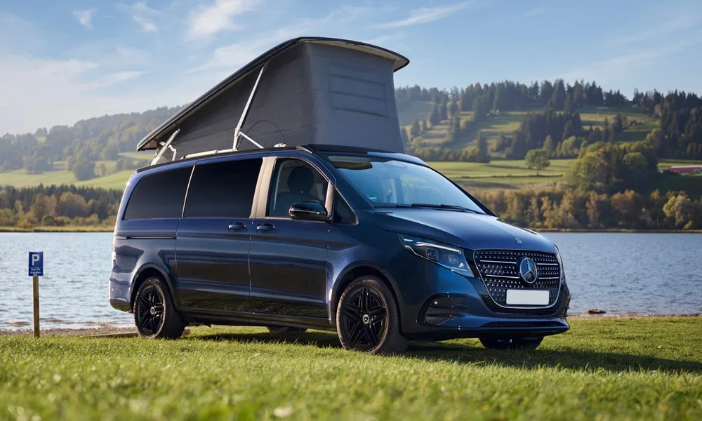 Фото Mercedes-Benz V-Class (2024) — вид спереди, фото 11. Синий кузов, строгая симметрия оптики — базовый ракурс знакомства с дизайном Mercedes-Benz V-Class (2024) — вид спереди, фото 11