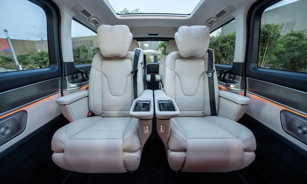 Фото Mercedes-Benz V-Class (2024) — задние сиденья. Посадка второго ряда: подголовники и подлокотник. Спинки складываются под длинные грузы у большинства версий Mercedes-Benz V-Class (2024) — задние сиденья