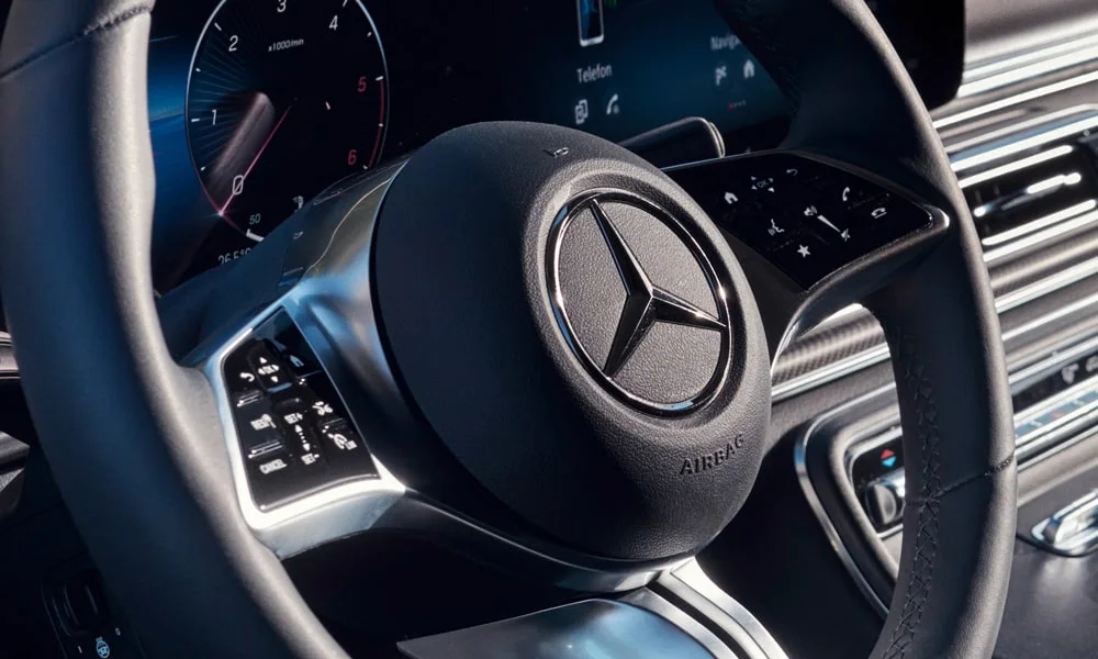 Фото Mercedes-Benz V-Class (2024) — руль. Обшивка обода и компоновка спиц крупным планом. Правильная посадка: руки на «9 и 3», приборы читаются поверх обода Mercedes-Benz V-Class (2024) — руль