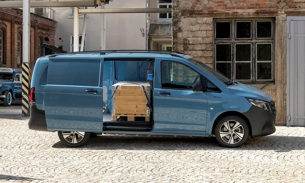 Фото Mercedes-Benz Vito (2024) — вид спереди, фото 9. Синий кузов, строгая симметрия оптики — базовый ракурс знакомства с дизайном. Рисунок ходовых огней — подпись модели, по нему её узнают в потоке Mercedes-Benz Vito (2024) — вид спереди, фото 9