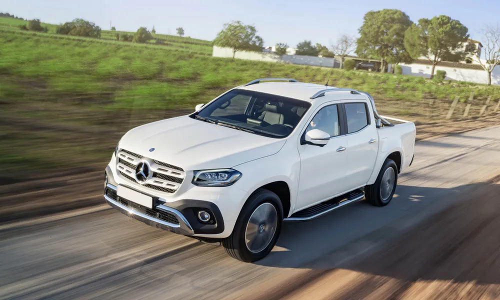 Фото Mercedes-Benz X-Class — вид спереди, фото 4. Кузов в белом цвете: рисунок оптики и решётки задаёт узнаваемое «лицо» модели. Дневные ходовые огни включаются автоматически с запуском Mercedes-Benz X-Class — вид спереди, фото 4