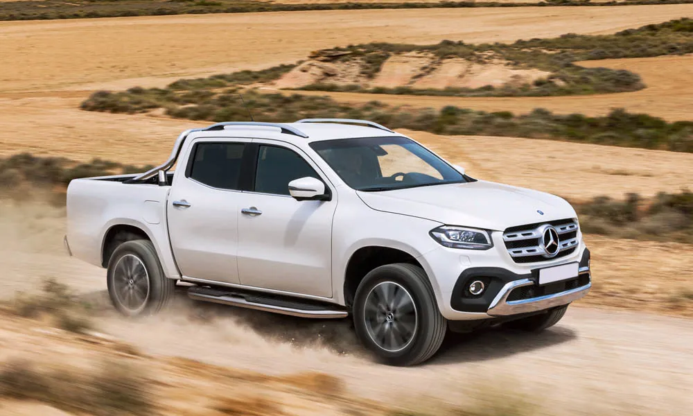 Фото Mercedes-Benz X-Class — вид спереди, фото 5. Передок в белом исполнении — крупная светотехника и выразительный бампер. Рисунок ходовых огней — подпись модели, по нему её узнают в потоке Mercedes-Benz X-Class — вид спереди, фото 5