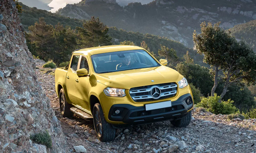 Фото Mercedes-Benz X-Class — вид спереди, фото 9. Кузов в жёлтом цвете: рисунок оптики и решётки задаёт узнаваемое «лицо» модели. Рисунок ходовых огней — подпись модели, по нему её узнают в потоке Mercedes-Benz X-Class — вид спереди, фото 9