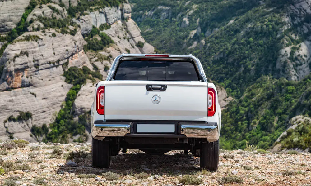 Фото Mercedes-Benz X-Class — вид сзади. Корма в белом цвете: графика фонарей и пластика пятой двери. Насадки выхлопа или их имитация внизу бампера различают версии Mercedes-Benz X-Class — вид сзади