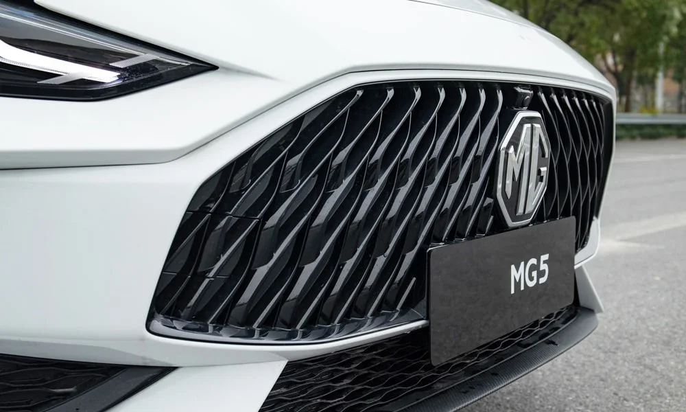 Фото MG 5 (2024) — решётка радиатора. Фирменный рисунок облицовки — визитная карточка марки. Активные жалюзи за решёткой закрываются на трассе ради аэродинамики — есть у ряда моделей MG 5 (2024) — решётка радиатора