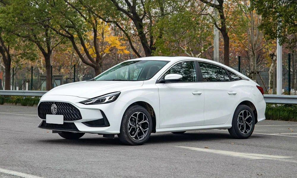 Фото MG 5 (2024) — вид сбоку, фото 2. Сбоку читаются линия остекления и характер выштамповок на белом кузове. Хромированные или чёрные молдинги окон отличают комплектации MG 5 (2024) — вид сбоку, фото 2