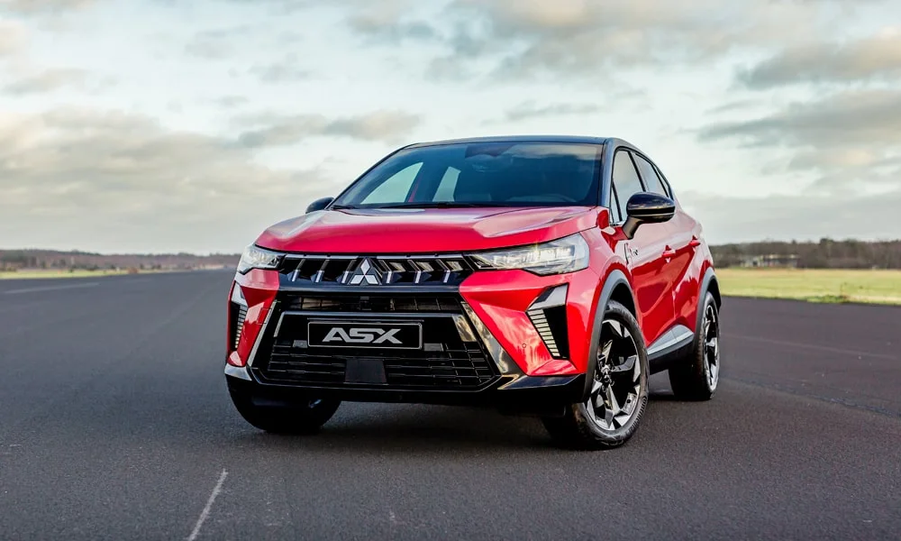 Фото Mitsubishi ASX (2024) — вид спереди, фото 6. Красный кузов, строгая симметрия оптики — базовый ракурс знакомства с дизайном Mitsubishi ASX (2024) — вид спереди, фото 6
