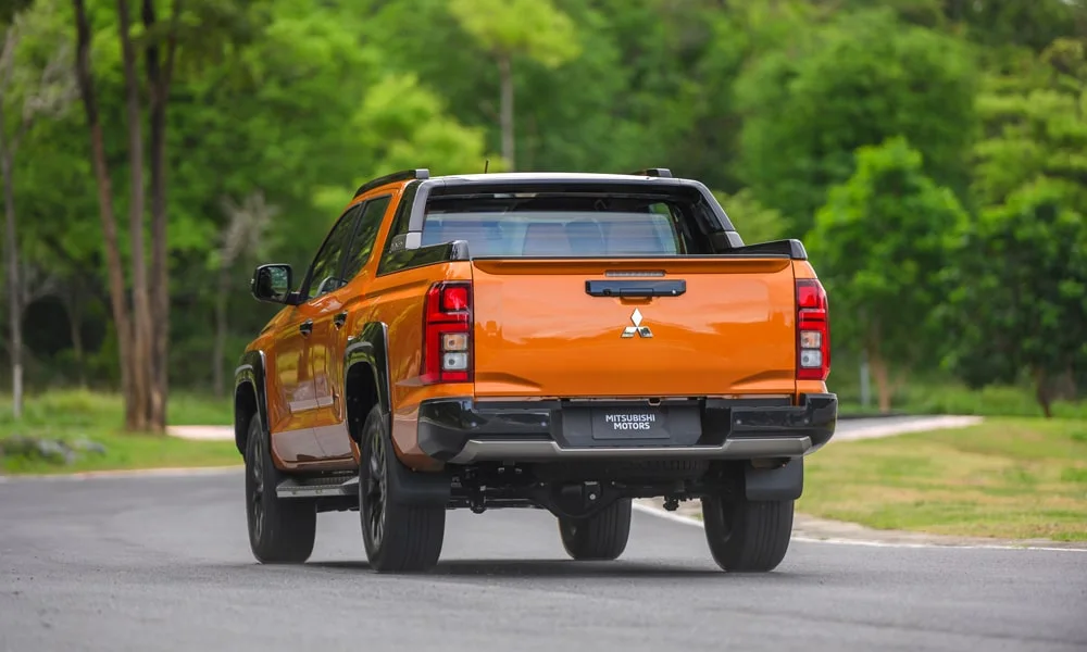 Фото Mitsubishi L200 (2024) — вид сзади, фото 4. Оранжевый кузов сзади — фонари и бампер определяют ночной образ модели. Светодиодная полоса или раздельные секции — задняя оптика стала главным украшением кормы Mitsubishi L200 (2024) — вид сзади, фото 4