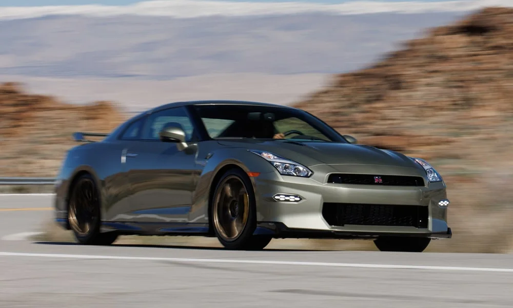 Фото Nissan GT-R — вид спереди, фото 3. Серый кузов, строгая симметрия оптики — базовый ракурс знакомства с дизайном. Рисунок ходовых огней — подпись модели, по нему её узнают в потоке Nissan GT-R — вид спереди, фото 3