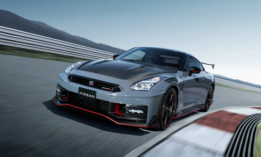 Фото Nissan GT-R — вид спереди, фото 9. Кузов в сером цвете: рисунок оптики и решётки задаёт узнаваемое «лицо» модели. Рисунок ходовых огней — подпись модели, по нему её узнают в потоке Nissan GT-R — вид спереди, фото 9