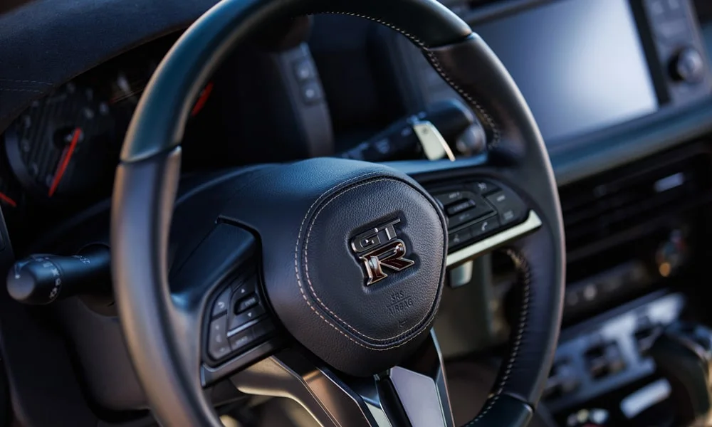 Фото Nissan GT-R — руль. Обшивка обода и компоновка спиц крупным планом Nissan GT-R — руль