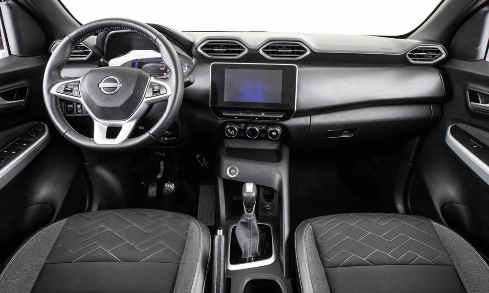 Фото Nissan Magnite (2024) — передняя панель. Панель в тёмной отделке — видна компоновка экранов и органов управления. Минимум физических кнопок — ставка на экранное управление Nissan Magnite (2024) — передняя панель