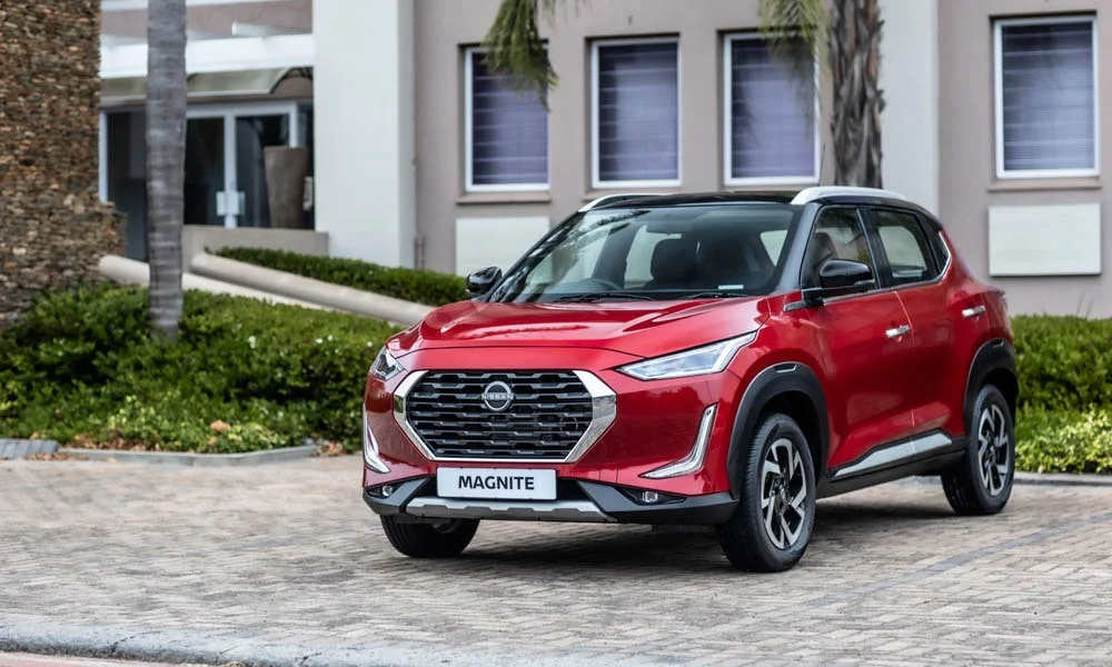 Фото Nissan Magnite (2024) — вид спереди, фото 7. Красный кузов, строгая симметрия оптики — базовый ракурс знакомства с дизайном. Рисунок ходовых огней — подпись модели, по нему её узнают в потоке Nissan Magnite (2024) — вид спереди, фото 7
