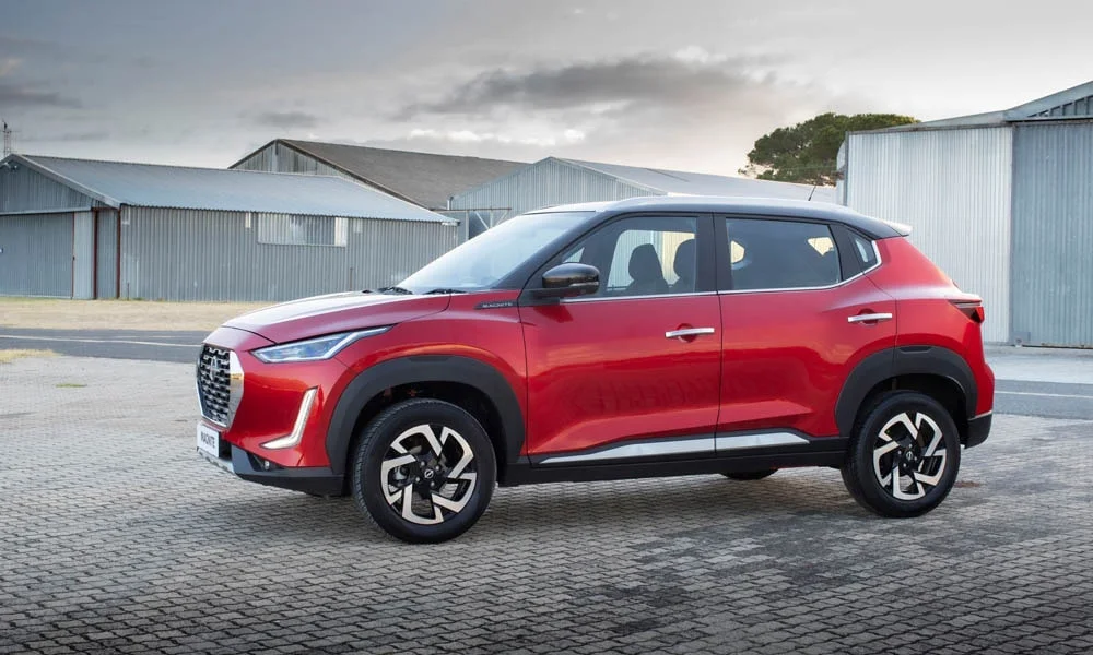 Фото Nissan Magnite (2024) — вид сбоку, фото 4. Сбоку читаются линия остекления и характер выштамповок на красном кузове. Длинная база — простор второго ряда; короткие свесы упрощают парковку Nissan Magnite (2024) — вид сбоку, фото 4
