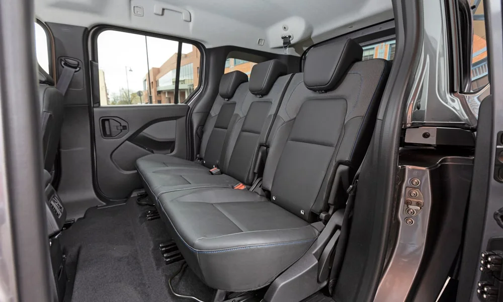 Фото Nissan Townstar — задние сиденья. Посадка второго ряда: подголовники и подлокотник. Крепления ISOFIX для детских кресел — в основании спинки Nissan Townstar — задние сиденья
