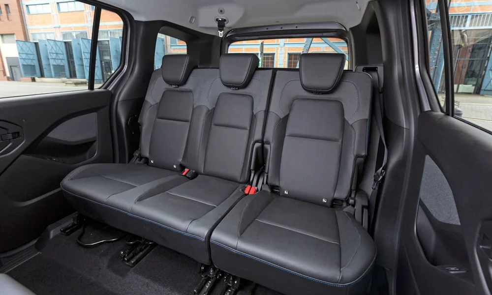 Фото Nissan Townstar — задние сиденья, фото 2. Посадка второго ряда: подголовники и подлокотник. Спинки складываются под длинные грузы у большинства версий Nissan Townstar — задние сиденья, фото 2