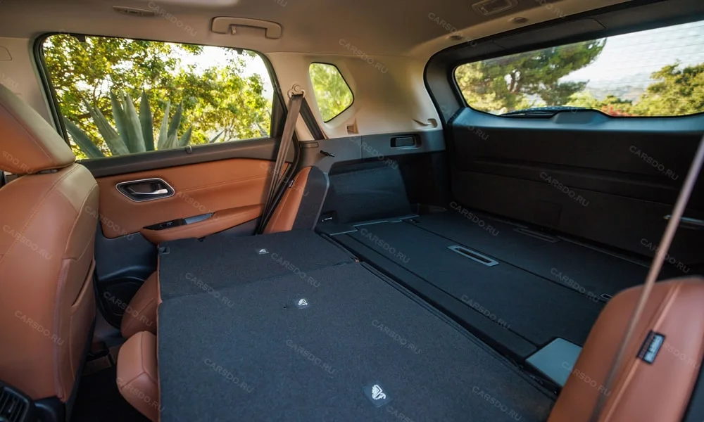 Фото Nissan X-Trail (2024) — багажник. Грузовой отсек с открытой дверью: погрузочная высота и ширина проёма. Электропривод двери с датчиком под бампером — руки заняты, багажник открыт Nissan X-Trail (2024) — багажник