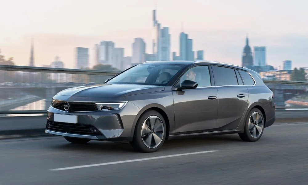 Фото Opel Astra Sports Tourer — вид спереди, фото 4. Серый кузов, строгая симметрия оптики — базовый ракурс знакомства с дизайном Opel Astra Sports Tourer — вид спереди, фото 4