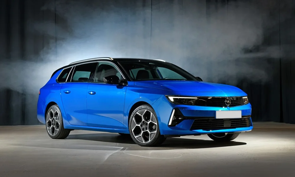 Фото Opel Astra Sports Tourer — вид спереди, фото 7. Синий кузов, строгая симметрия оптики — базовый ракурс знакомства с дизайном. Дневные ходовые огни включаются автоматически с запуском Opel Astra Sports Tourer — вид спереди, фото 7