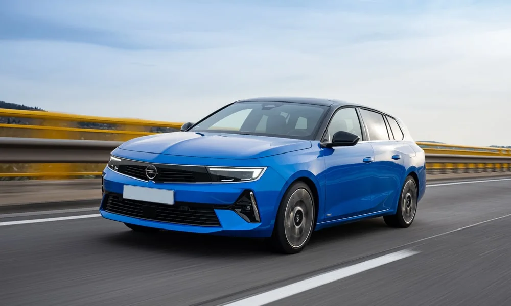 Фото Opel Astra Sports Tourer — вид спереди, фото 8. Синий кузов, строгая симметрия оптики — базовый ракурс знакомства с дизайном. Дневные ходовые огни включаются автоматически с запуском Opel Astra Sports Tourer — вид спереди, фото 8