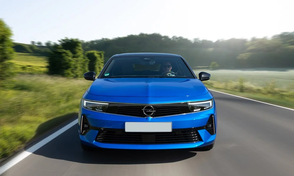 Фото Opel Astra Sports Tourer — вид спереди, фото 10. Синий кузов, строгая симметрия оптики — базовый ракурс знакомства с дизайном. Дневные ходовые огни включаются автоматически с запуском Opel Astra Sports Tourer — вид спереди, фото 10