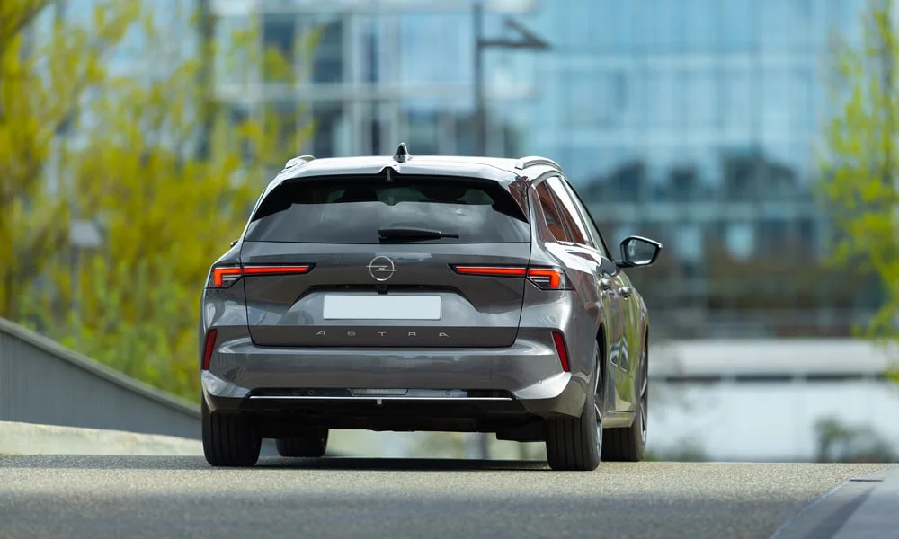 Фото Opel Astra Sports Tourer — вид сзади, фото 3. Серый кузов сзади — фонари и бампер определяют ночной образ модели. Насадки выхлопа или их имитация внизу бампера различают версии Opel Astra Sports Tourer — вид сзади, фото 3