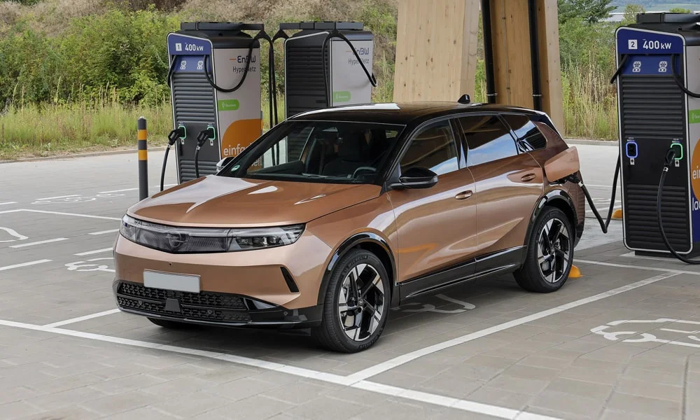 Фото Opel Grandland X (2024) — вид спереди, фото 9. Передок в коричневом исполнении — крупная светотехника и выразительный бампер. Рисунок ходовых огней — подпись модели, по нему её узнают в потоке Opel Grandland X (2024) — вид спереди, фото 9