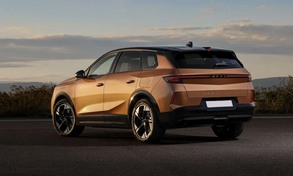 Фото Opel Grandland X (2024) — вид сзади, фото 4. Корма в коричневом цвете: графика фонарей и пластика пятой двери. Светодиодная полоса или раздельные секции — задняя оптика стала главным украшением кормы Opel Grandland X (2024) — вид сзади, фото 4