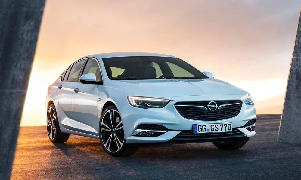 Фото Opel Insignia Grand Sport — вид спереди, фото 7. Белый кузов, строгая симметрия оптики — базовый ракурс знакомства с дизайном Opel Insignia Grand Sport — вид спереди, фото 7