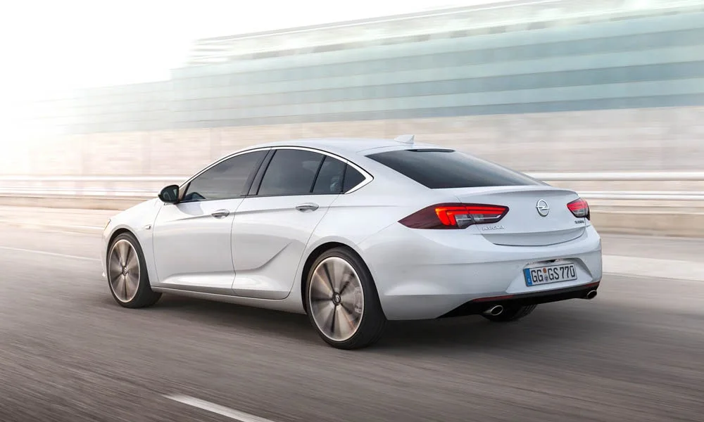 Фото Opel Insignia Grand Sport — вид сзади, фото 6. Корма в белом цвете: графика фонарей и пластика пятой двери. Насадки выхлопа или их имитация внизу бампера различают версии Opel Insignia Grand Sport — вид сзади, фото 6