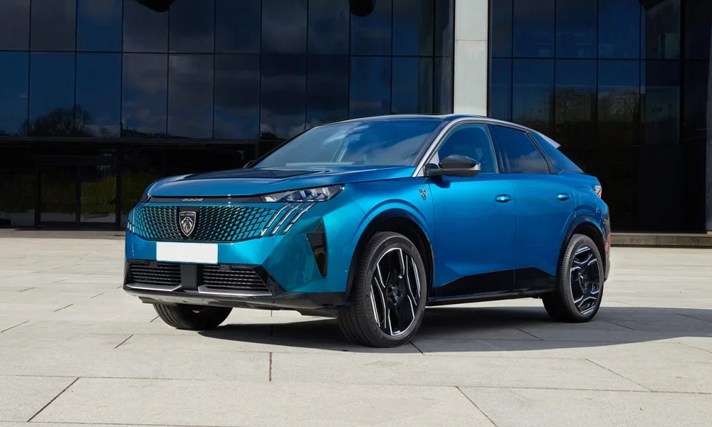 Фото Peugeot 3008 (2024) — вид спереди, фото 4. Синий кузов, строгая симметрия оптики — базовый ракурс знакомства с дизайном. Рисунок ходовых огней — подпись модели, по нему её узнают в потоке Peugeot 3008 (2024) — вид спереди, фото 4