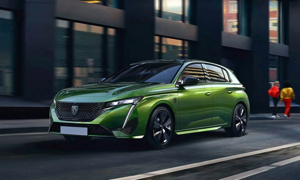 Фото Peugeot 308 — вид спереди, фото 7. Зелёный кузов, строгая симметрия оптики — базовый ракурс знакомства с дизайном. Рисунок ходовых огней — подпись модели, по нему её узнают в потоке Peugeot 308 — вид спереди, фото 7