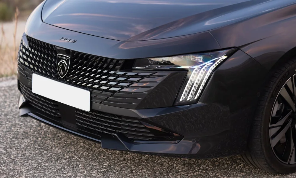 Фото Peugeot 508 (2024) — вид спереди, фото 6. Чёрный кузов, строгая симметрия оптики — базовый ракурс знакомства с дизайном. Рисунок ходовых огней — подпись модели, по нему её узнают в потоке Peugeot 508 (2024) — вид спереди, фото 6