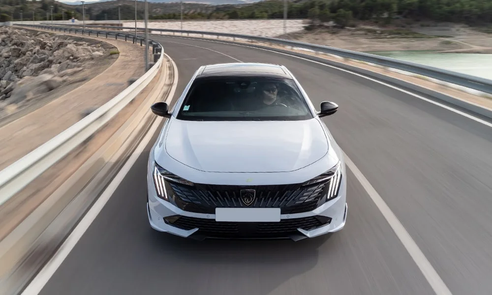 Фото Peugeot 508 (2024) — вид спереди, фото 7. Передок в белом исполнении — крупная светотехника и выразительный бампер. Рисунок ходовых огней — подпись модели, по нему её узнают в потоке Peugeot 508 (2024) — вид спереди, фото 7
