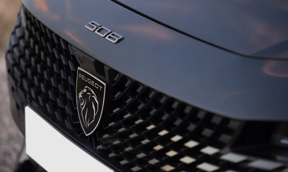 Фото Peugeot 508 (2024) — решётка радиатора. Фирменный рисунок облицовки — визитная карточка марки. Активные жалюзи за решёткой закрываются на трассе ради аэродинамики — есть у ряда моделей Peugeot 508 (2024) — решётка радиатора