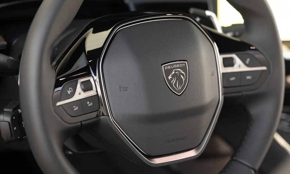Фото Peugeot 508 (2024) — руль. Обшивка обода и компоновка спиц крупным планом. Правильная посадка: руки на «9 и 3», приборы читаются поверх обода Peugeot 508 (2024) — руль
