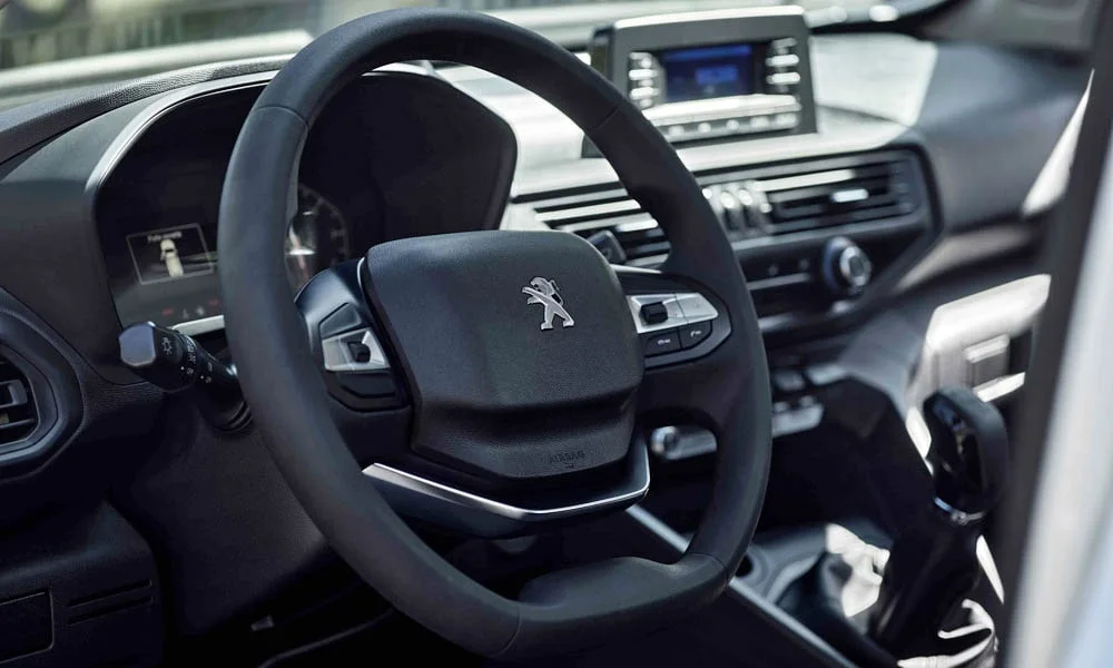 Фото Peugeot Landtrek (2024) — руль. Обшивка обода и компоновка спиц крупным планом. Правильная посадка: руки на «9 и 3», приборы читаются поверх обода Peugeot Landtrek (2024) — руль