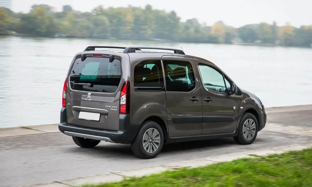 Фото Peugeot Partner Crossway — вид сзади, фото 3. Линия крыши, стойки и задняя дверь в сером исполнении. Насадки выхлопа или их имитация внизу бампера различают версии Peugeot Partner Crossway — вид сзади, фото 3