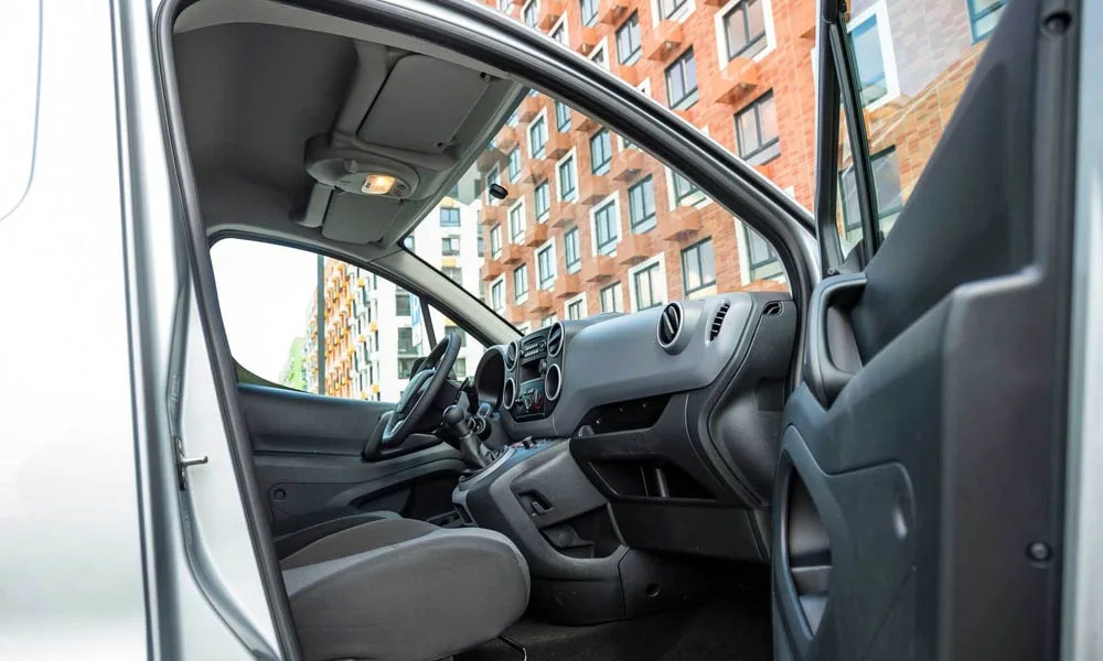 Фото Peugeot Partner — интерьер. Общий план салона: архитектура панели, консоль и кресла. Уровень отделки читается по стыкам панелей и мягким поверхностям в зонах касания Peugeot Partner — интерьер