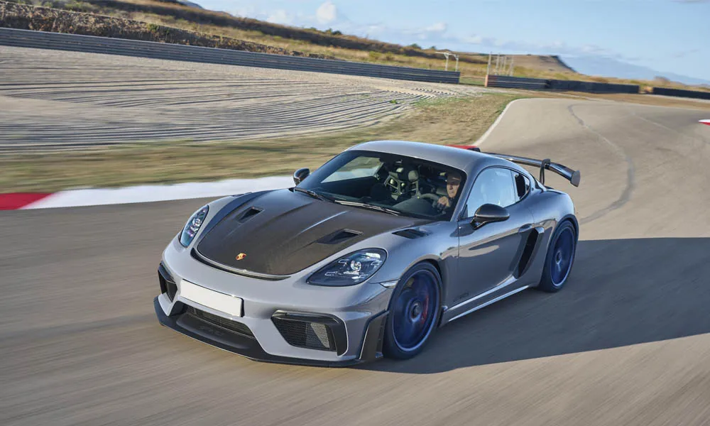 Фото Porsche 718 Cayman GT4 RS (2024) — вид спереди, фото 5. Кузов в сером цвете: рисунок оптики и решётки задаёт узнаваемое «лицо» модели Porsche 718 Cayman GT4 RS (2024) — вид спереди, фото 5