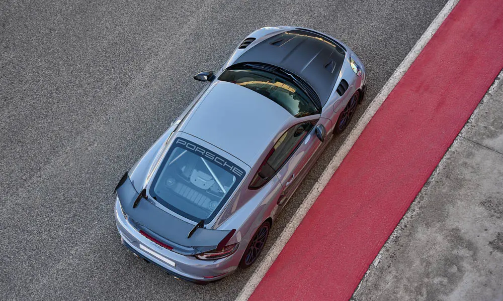 Фото Porsche 718 Cayman GT4 RS (2024) — крыша. Линия крыши и панорамное остекление с высоты. Панорамное стекло зрительно увеличивает салон; шторка спасает в жару Porsche 718 Cayman GT4 RS (2024) — крыша